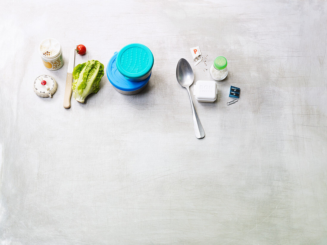 An arrangement of Tupperware, vegetables, spices and a kitchen timer