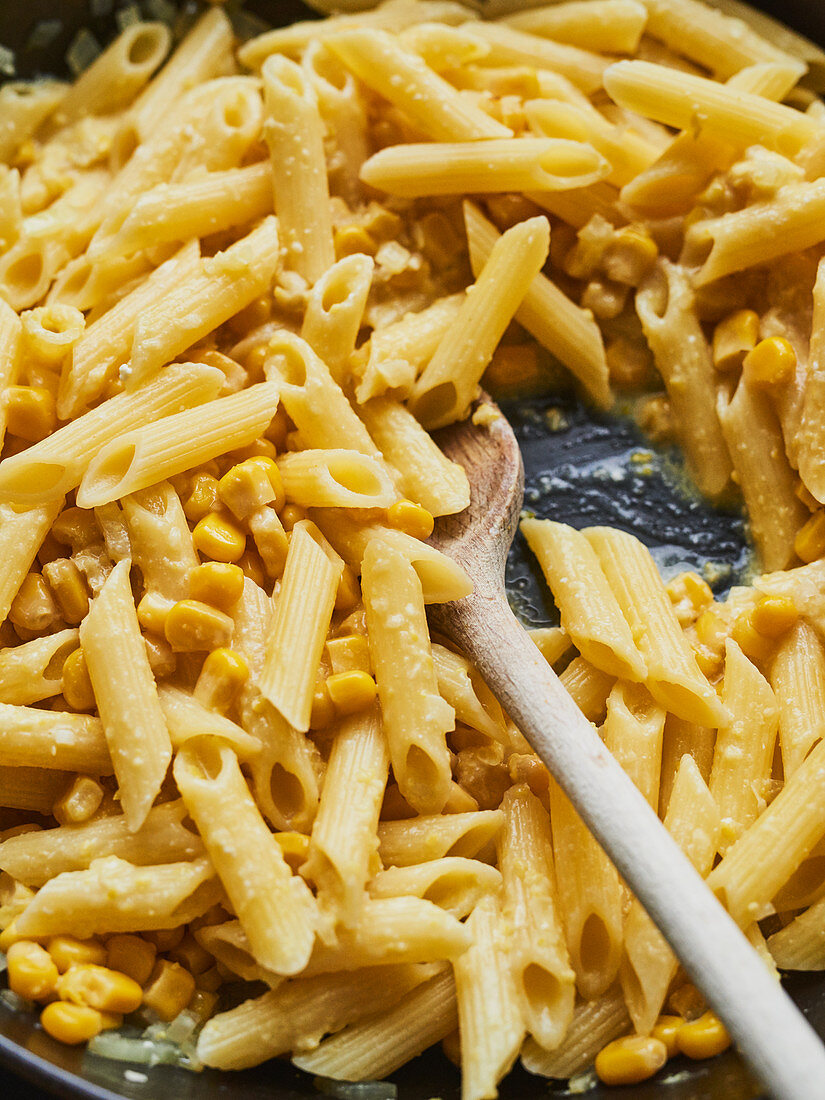 Penne pasta with sweetcorn being fried