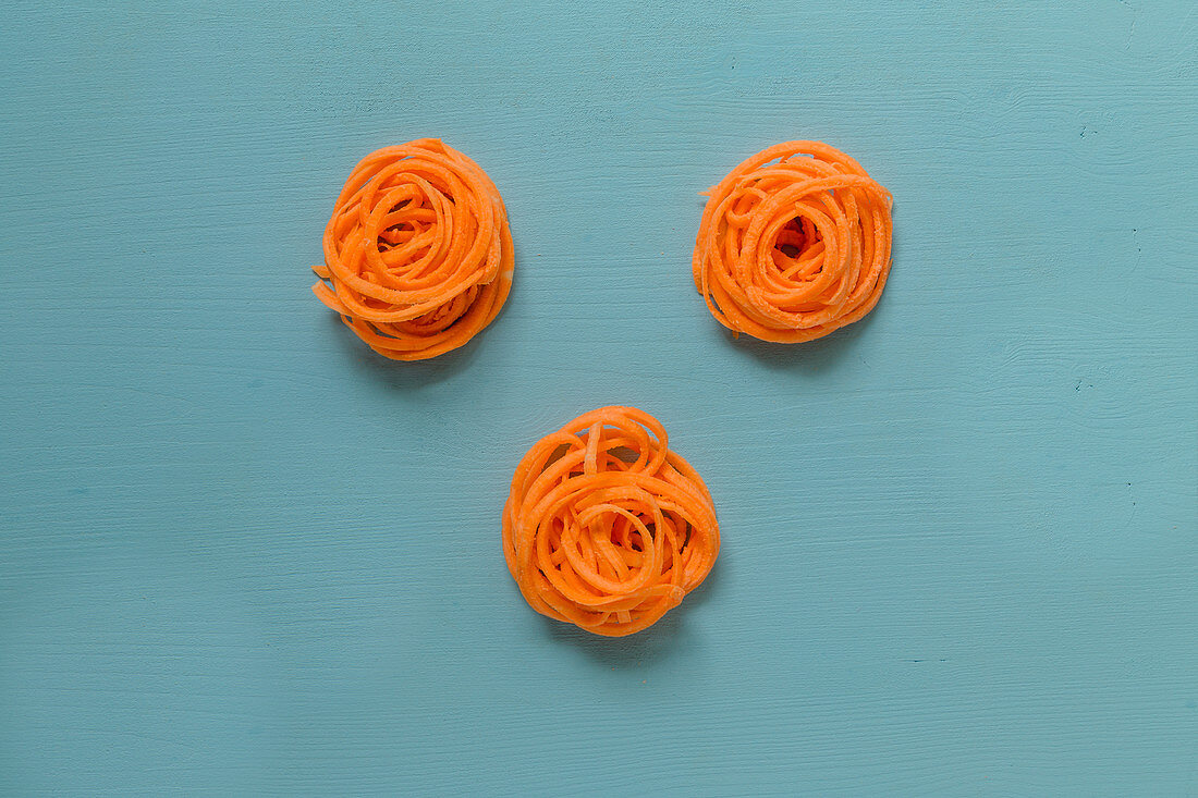 Vegetable spiral nests on a blue surface (seen from above)