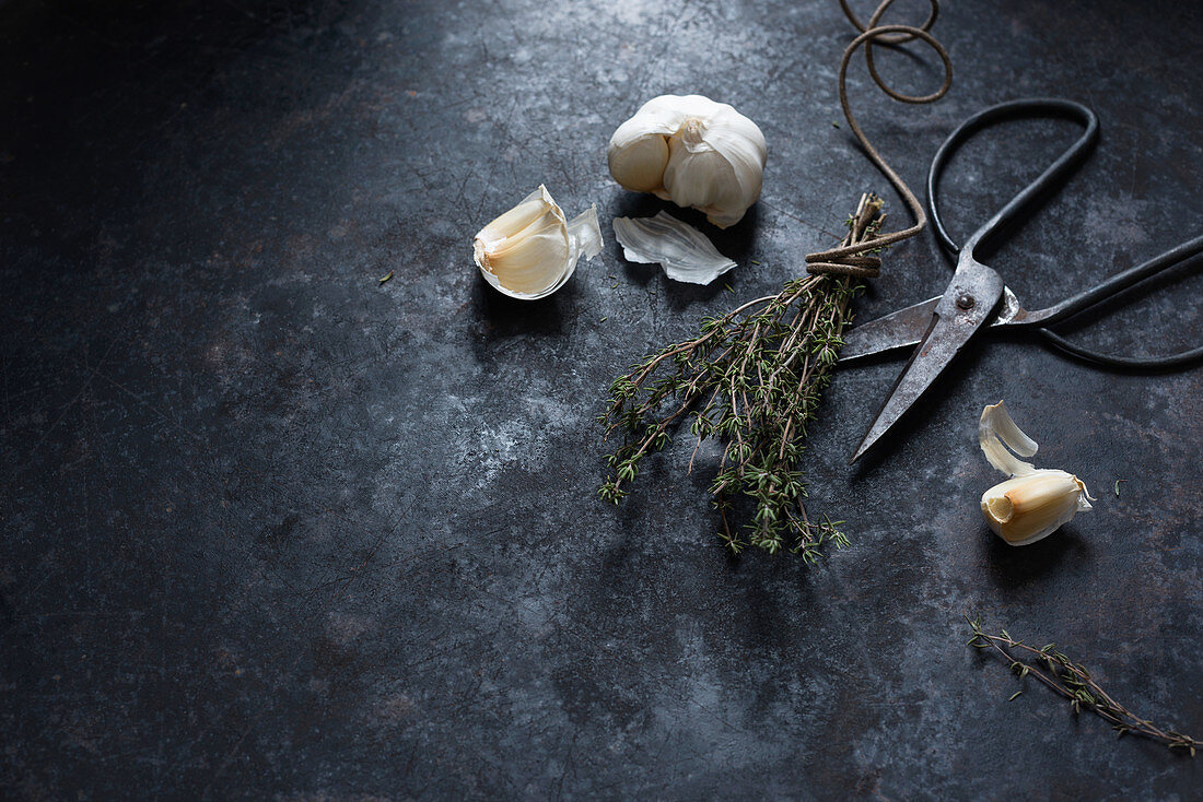 An arrangement of thyme, garlic and scissors