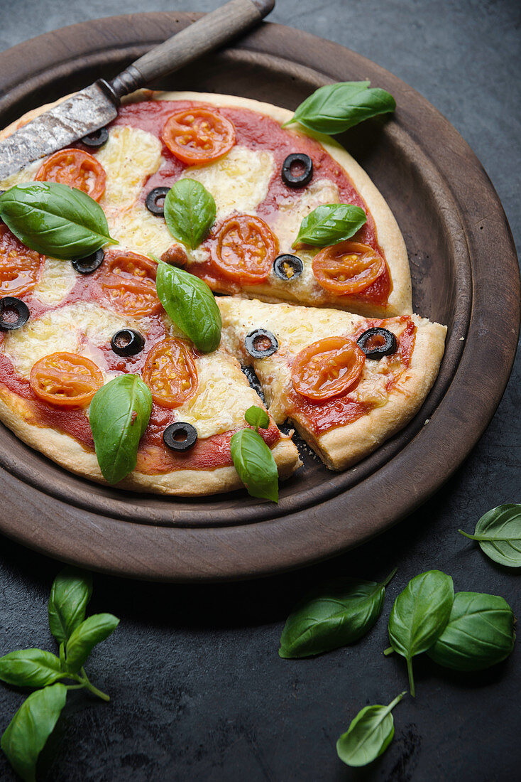 Vegane Blumenkohl-Pizza mit Tomaten, Oliven, Basilikum und veganem Käseersatz