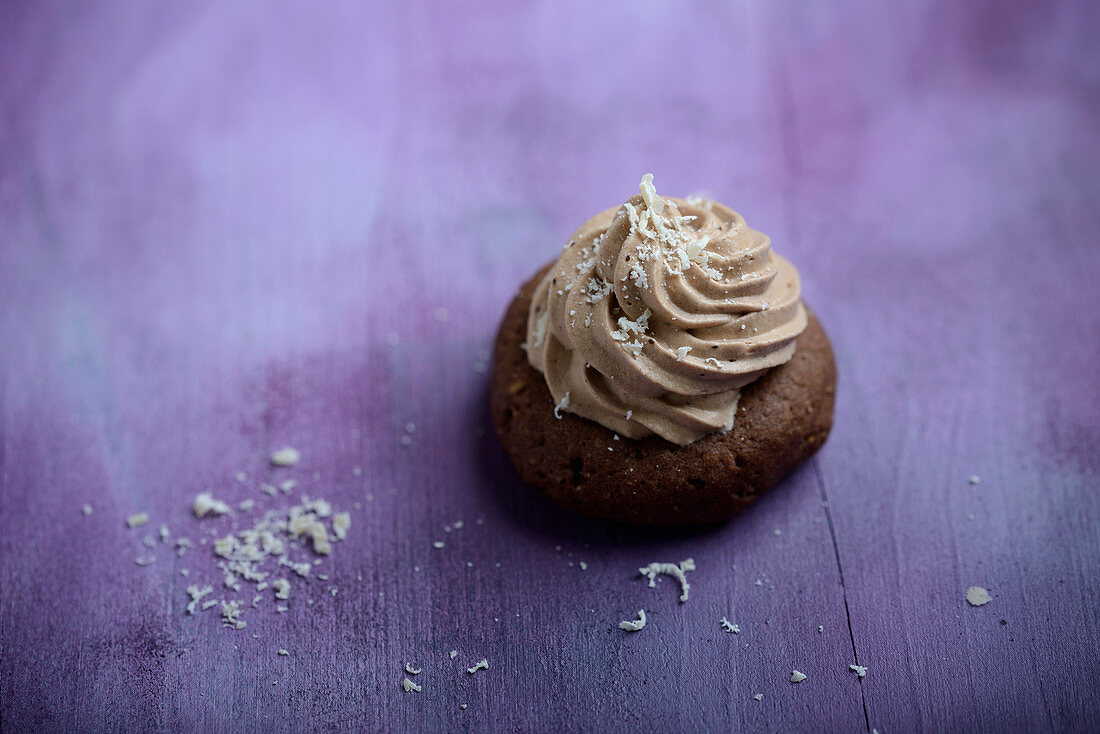 Veganes Kaffeeplätzchen mit Nougatsahne, bestreut mit geraspelter Reismilchschokolade