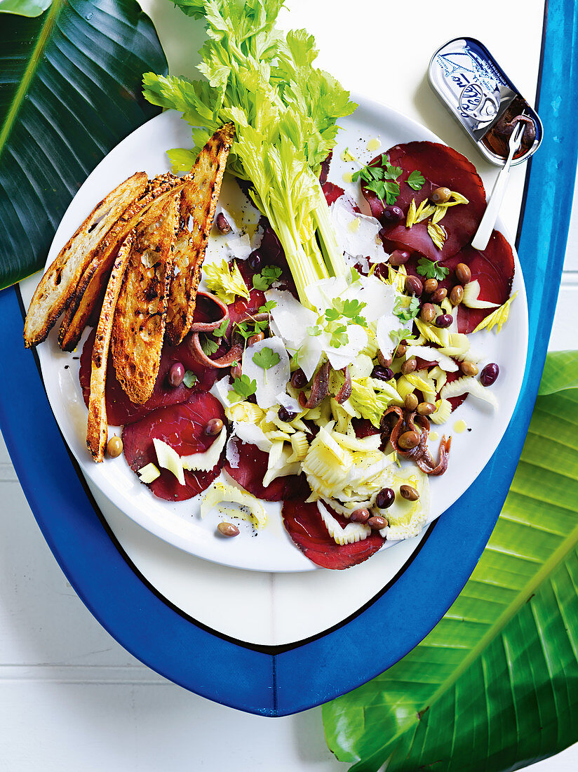 Antipasti: Staudensellerie, Anchovis, schwarze Oliven und Bresaola