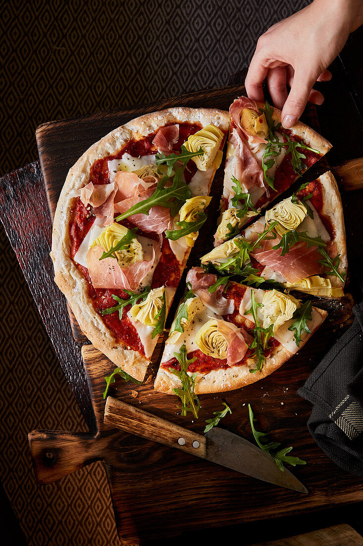 Pizza with ham, goat's cheese and rocket