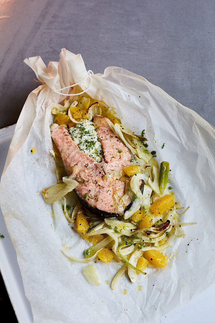 Salmon on a bed of orange fennel on parchment paper