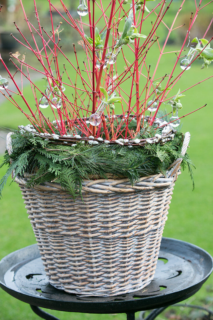 Weidenkorb mit floristischer Winterdekoration