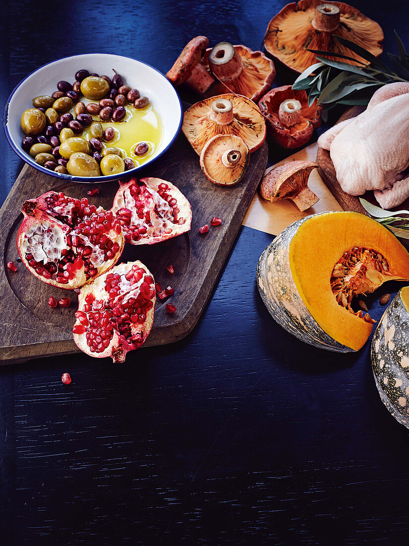 Ingredients for autumnal dishes: pomegranate, olives, mushrooms and pumpkin