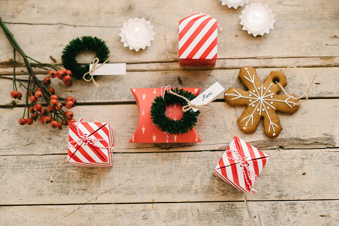 Guest favours in read-and-white striped boxes, gingerbread Christmas-tree decoration and small wreath