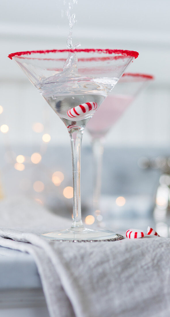 Drink in Martiniglas mit Weihnachtsbonbon gießen