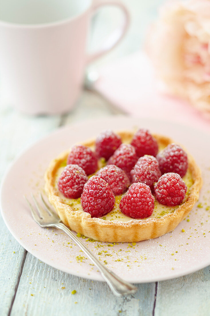 A marzipan tartlet with raspberries and pistachios