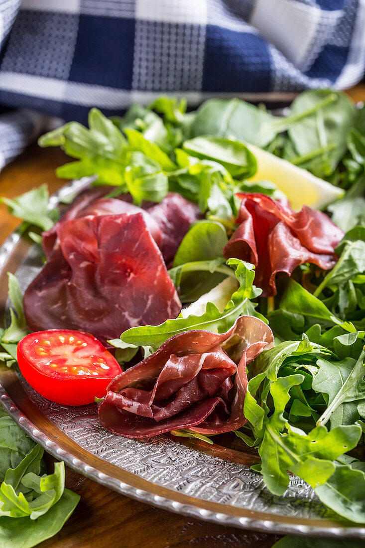 Salad bresaola arugula baby spinach tomatoes lime and cheese parmesan