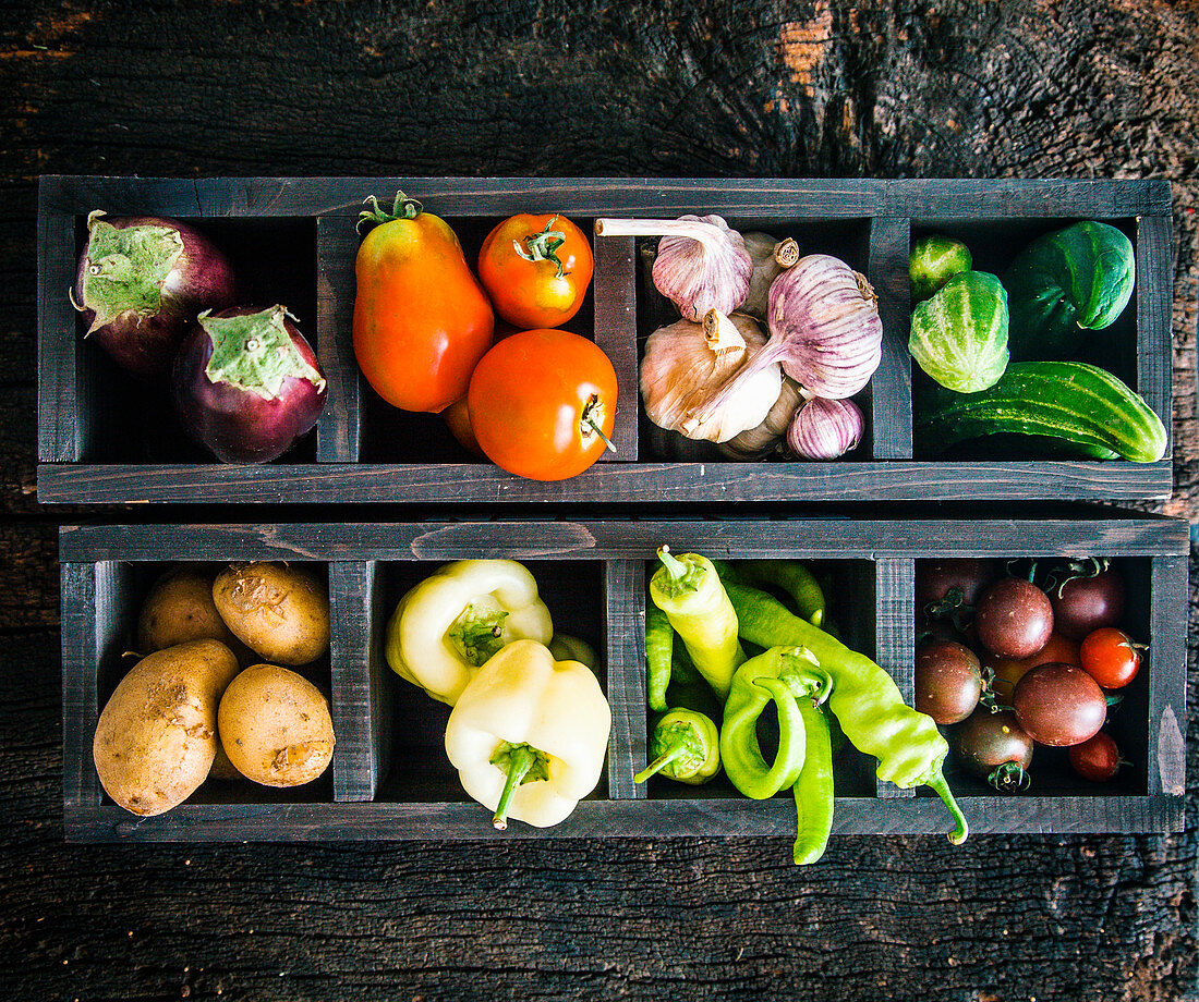 Fresh vegetables in compartments in two wooden boxes (seen from above)