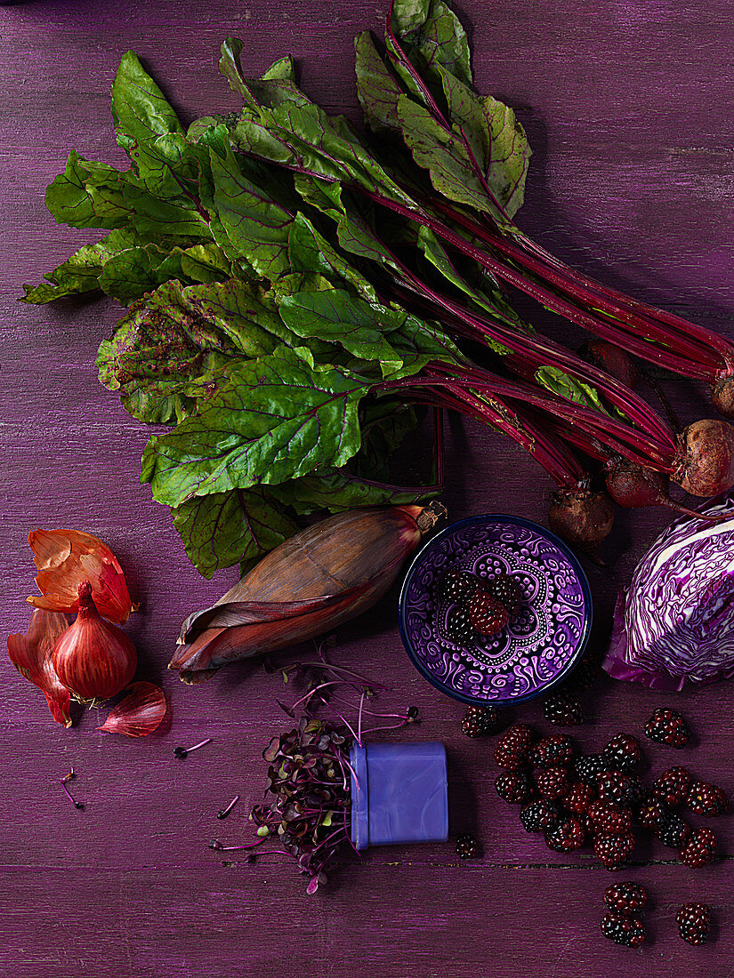A still life of purple vegetables and blackberries