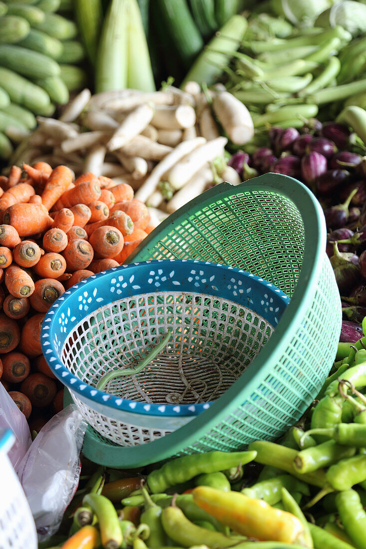 A vegetable stand with plastic bowls in the foreground
