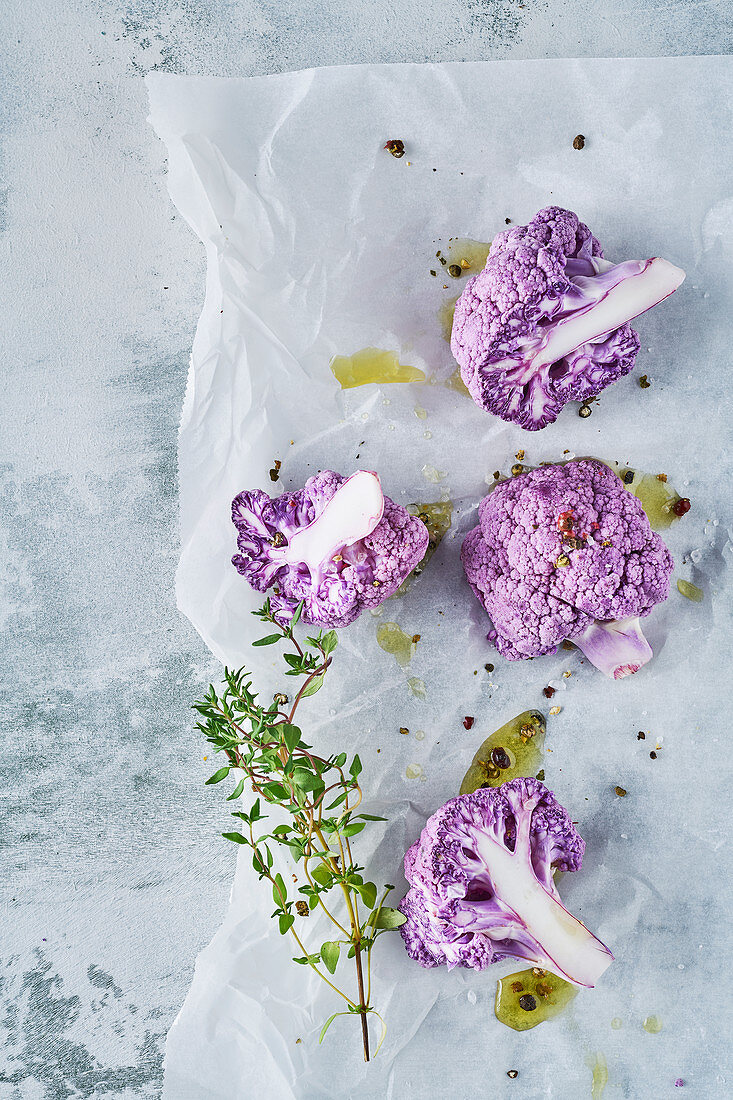 Purple cauliflower with thyme and olive oil on baking paper
