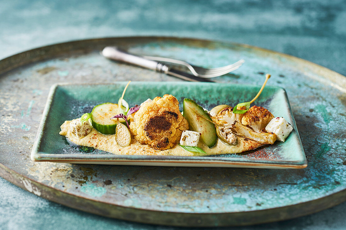 Roasted cauliflower with almond puree, apple capers, pickled cucumber, feta cheese and spring onion