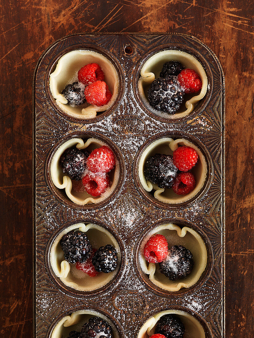 Berry tartlets with sugar in a muffin tin