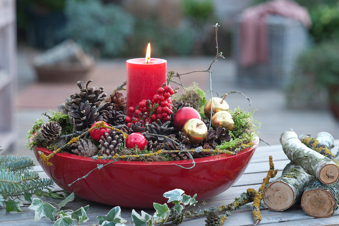 Candle decorated festively in red bowl