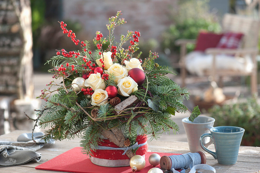 Christmas bouquet with roses, fir branches, berries and baubles