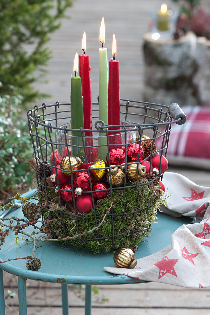 Candle arrangement in a wire basket as Advent wreath