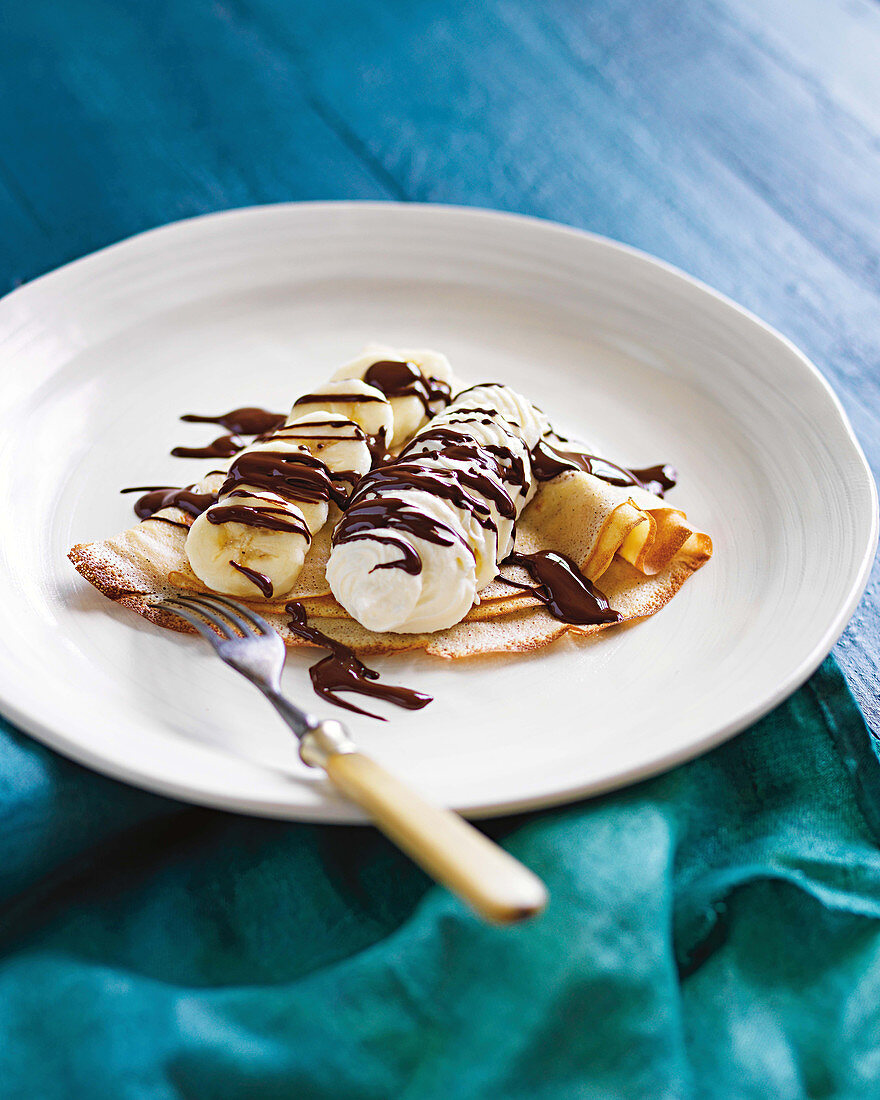 Crepes with bananas, chocolate sauce and chantilly