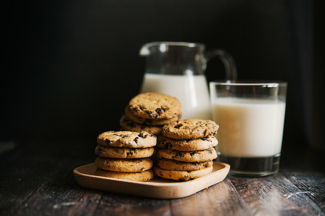 Chocolate chip cookies, with milk in a glass and pitcher