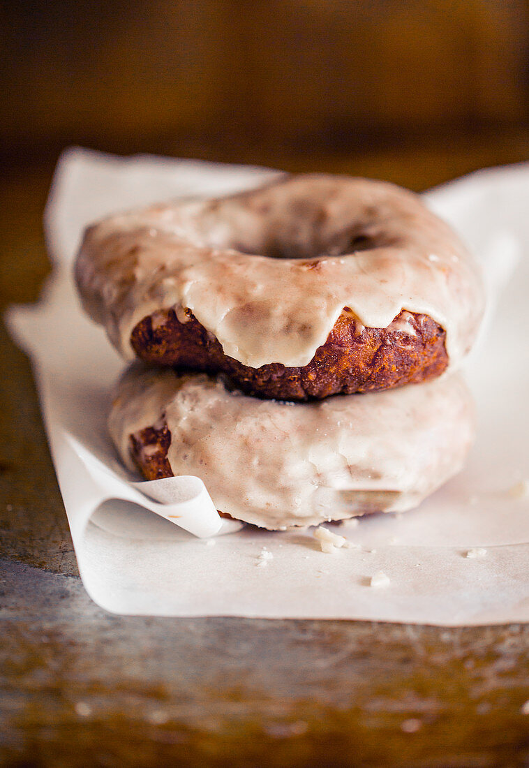 Zwei glutenfreie Donuts mit Chai-Glasur auf Papier