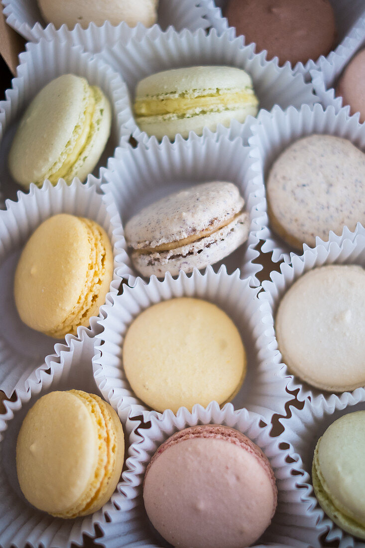 Various French macarons in paper cups