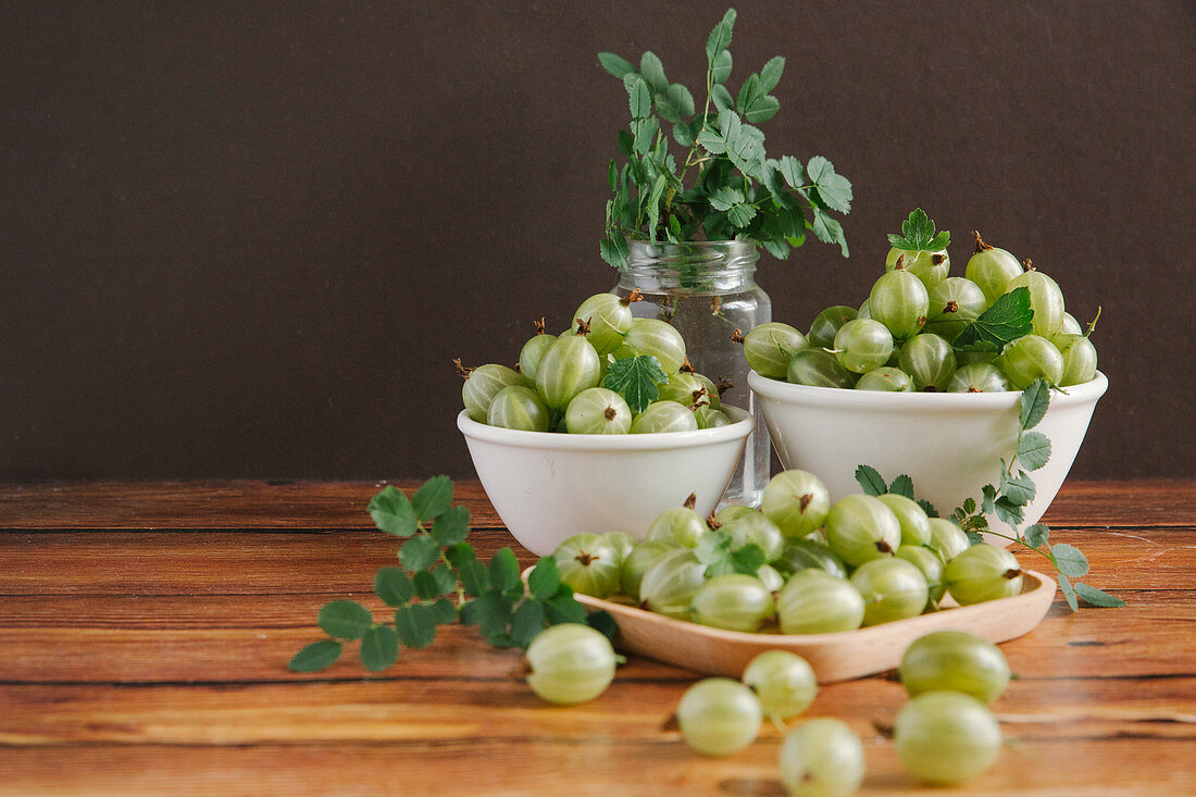 Gooseberries in small bowls on a wooden table