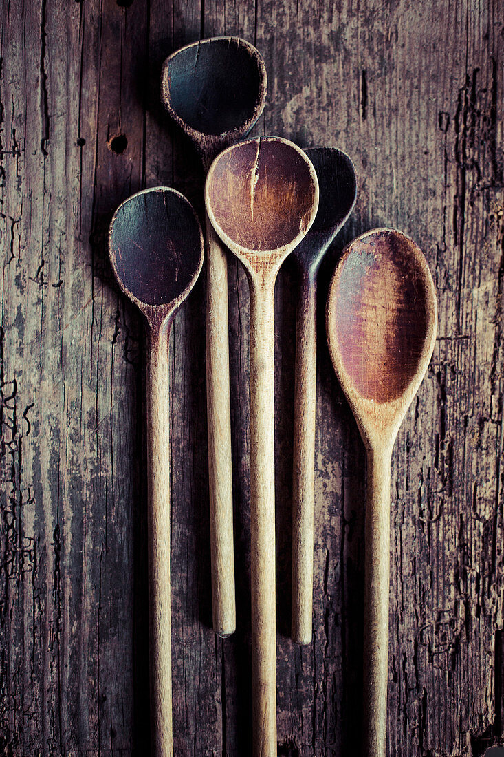 Several old wooden spoons on a wooden background