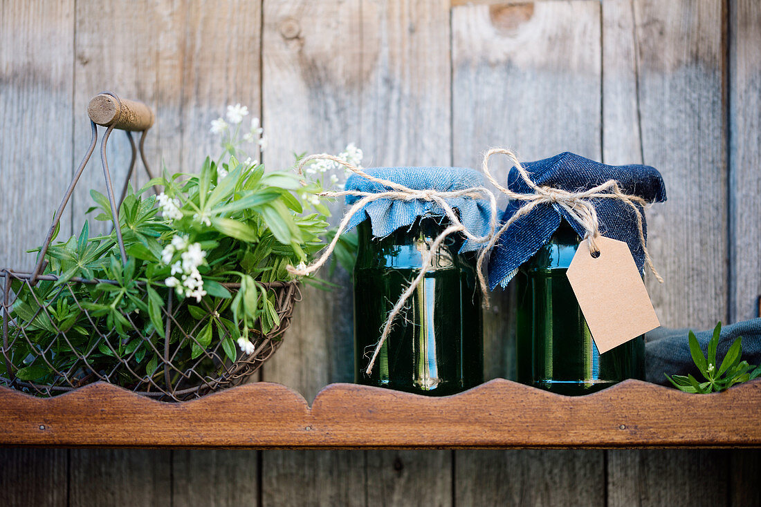 Jars of home-made sweet woodruff jelly on wooden shelf