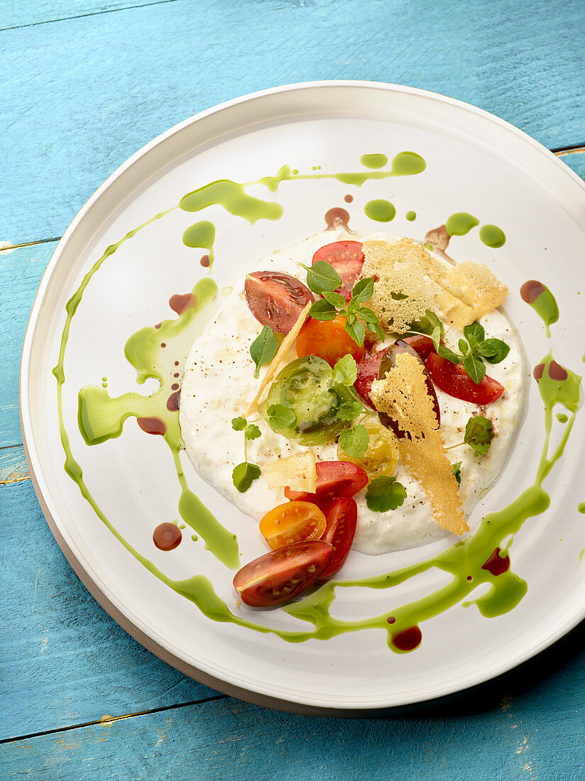 Burrata with red and green tomatoes, balsamic and basil oil