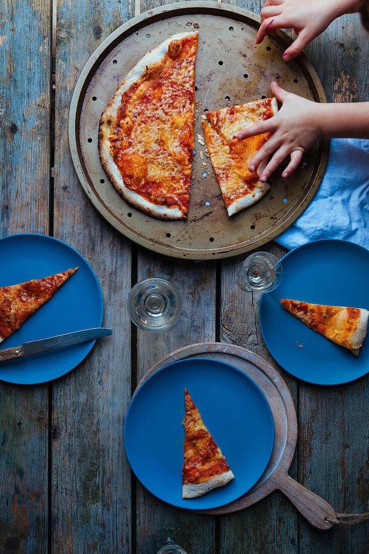 Pizza mit Kinderhänden