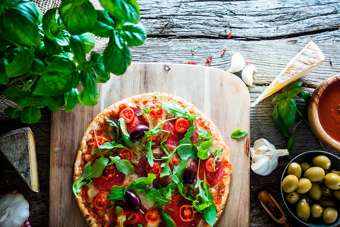 Fresh italian pizza on wood, cheese, salami and tomatoes