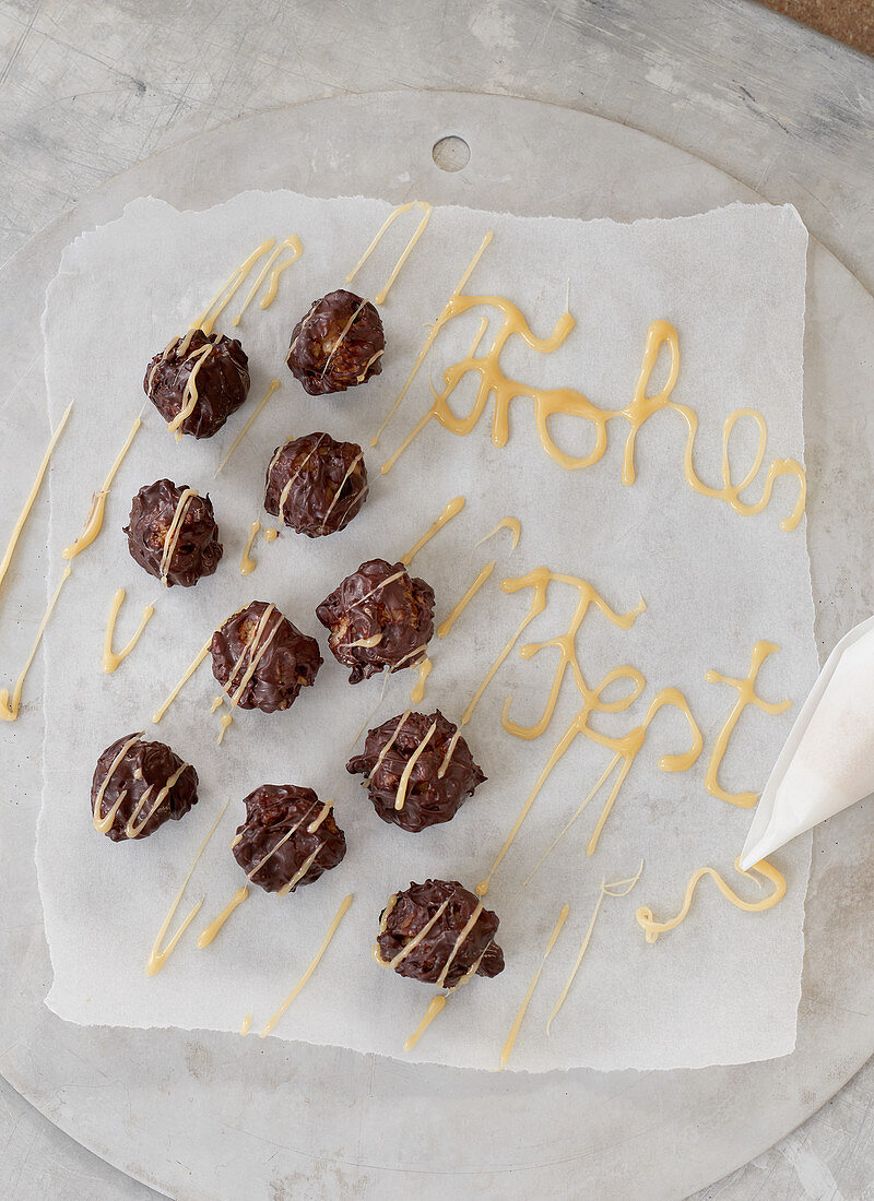 Cappuccino pralines on paper decorated with the words 'Frohes Fest'