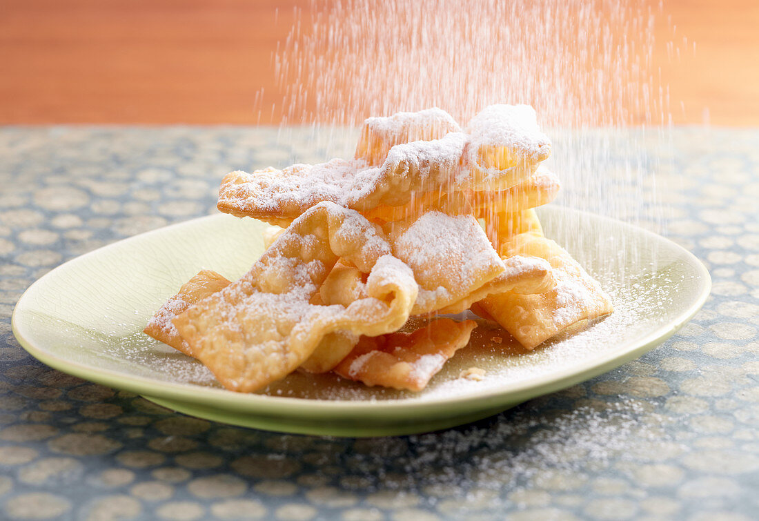 Faworki (Polish carnival pastries) being dusted with icing sugar