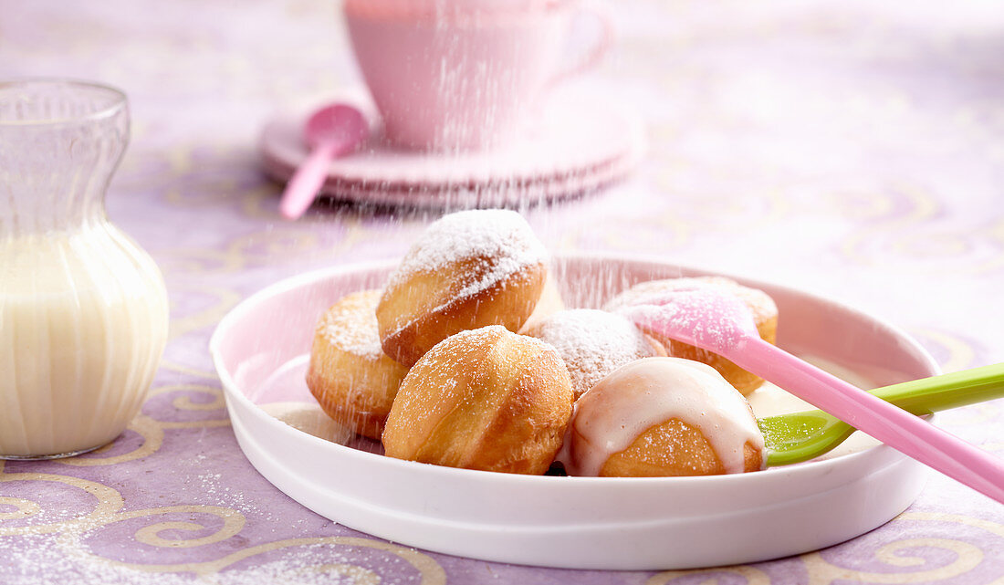 Fettgebackene süsse Hefebällchen mit Vanillesauce und Puderzucker