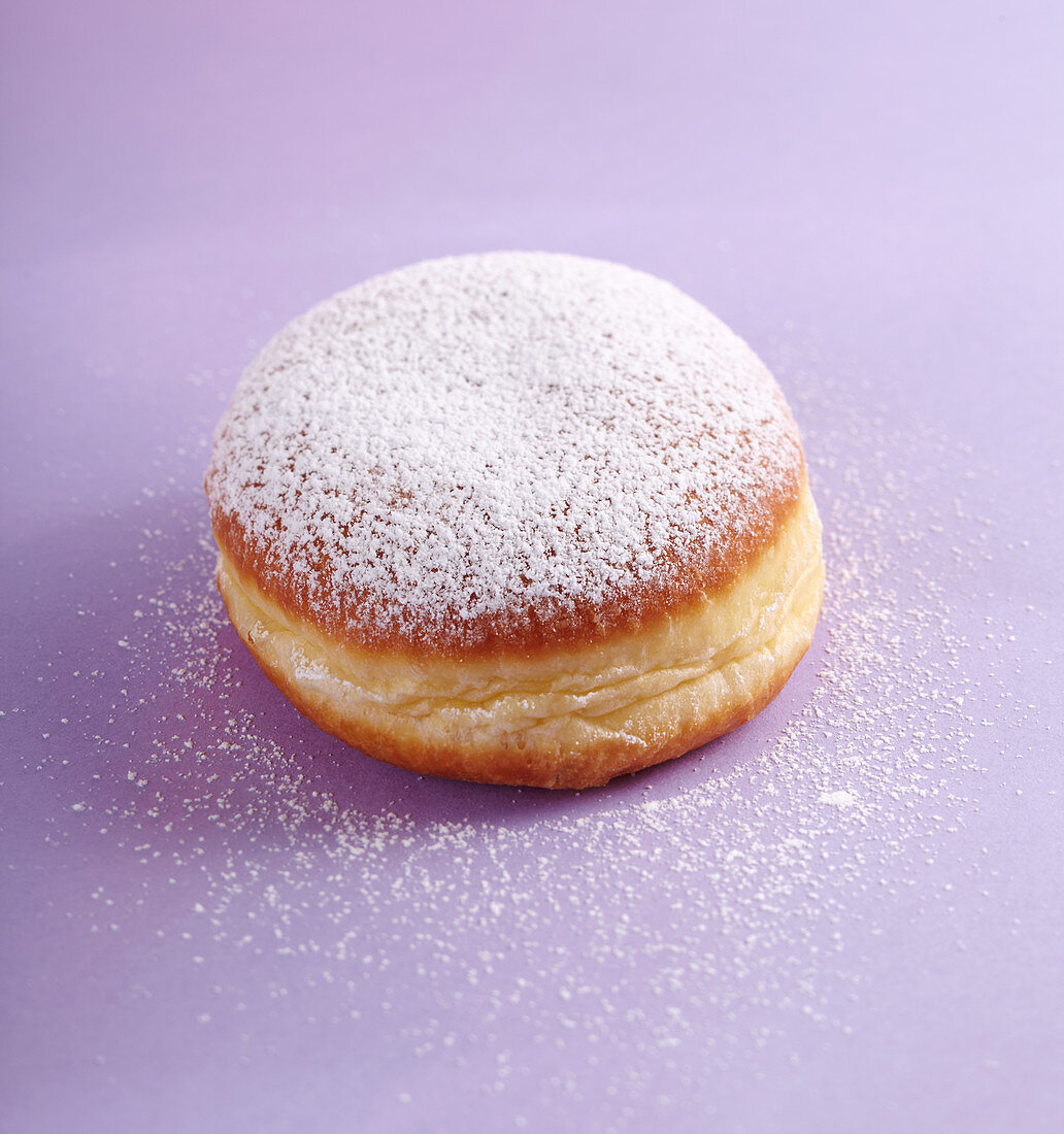 A carnival doughnut with icing sugar