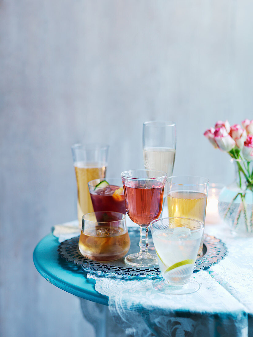 Various cocktails on a table with a flower vase