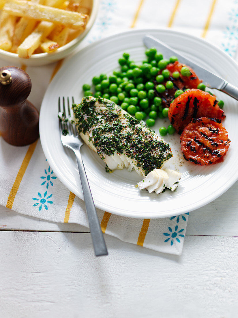 Fish in a herb coat with grilled tomatoes, peas and French fries