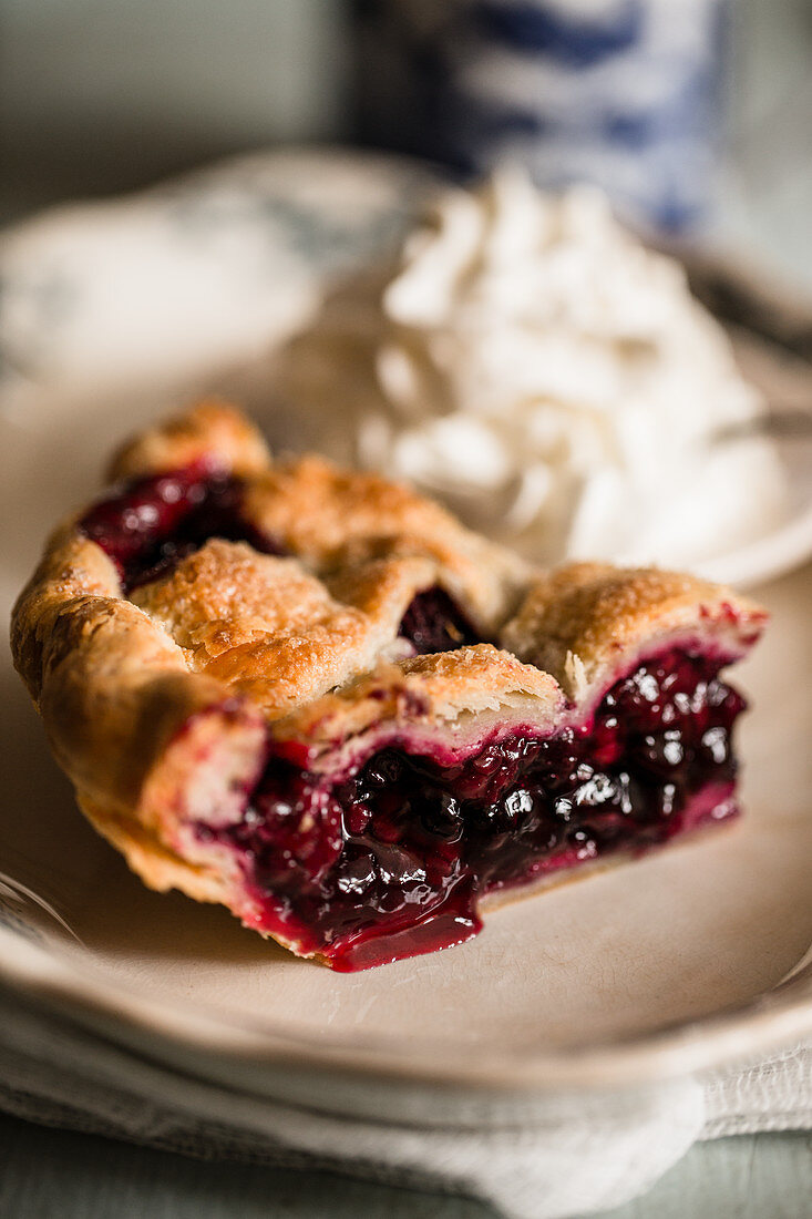 A piece of blueberry pie with cream