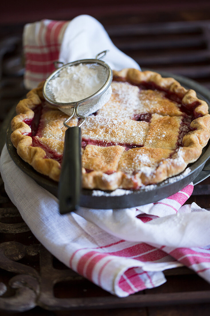 Cherry pie with a pastry lattice and powdered sugar