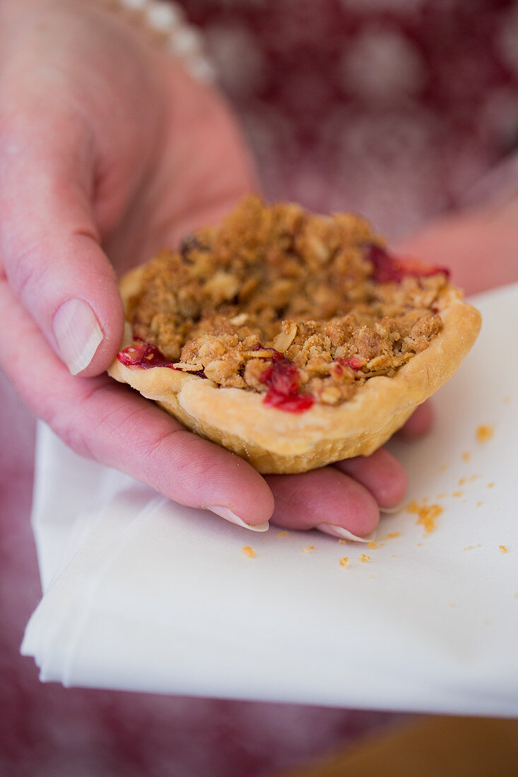 A woman holding a mini pie with berries