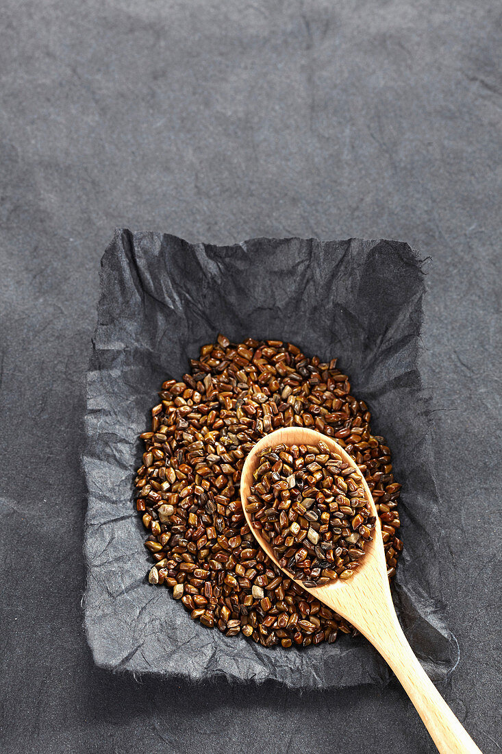 Cassia seeds on a spoon and on paper