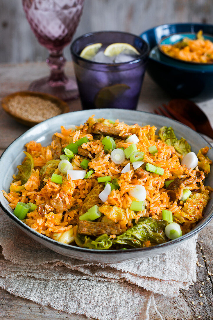 A bowl of kimchi fried rice with pork and green onions