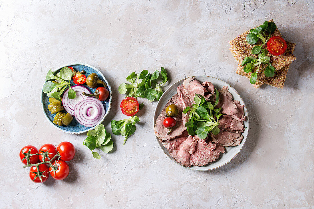 Zutaten für Roggenbrotsandwiches mit Rindfleisch, Feldsalat und Tomaten