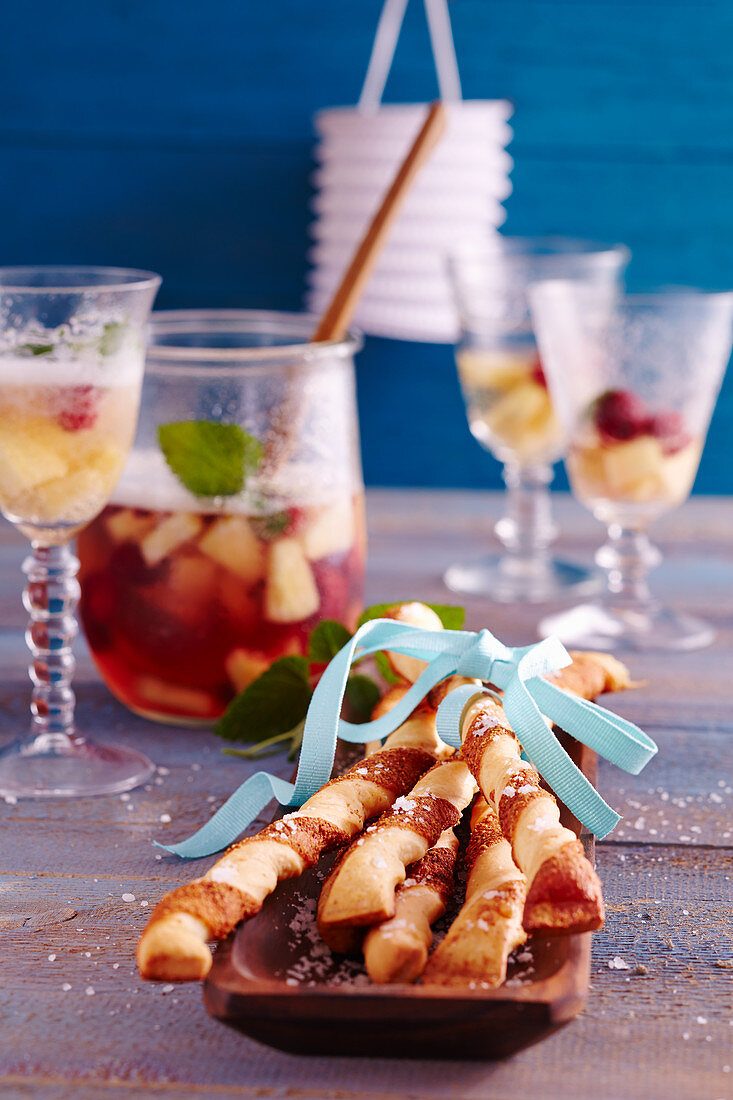 Pineapple and raspberry punch with spicy yeast dough and puff pasty Parmesan sticks