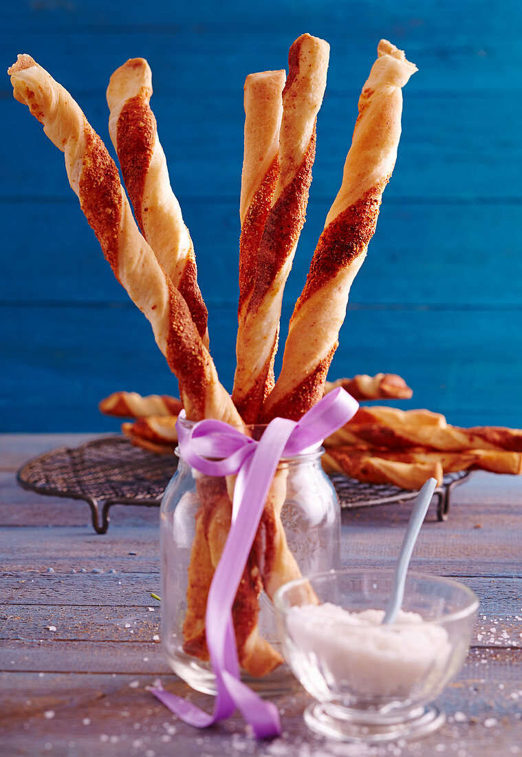 Spicy yeast dough and puff pastry Parmesan sticks in a glass