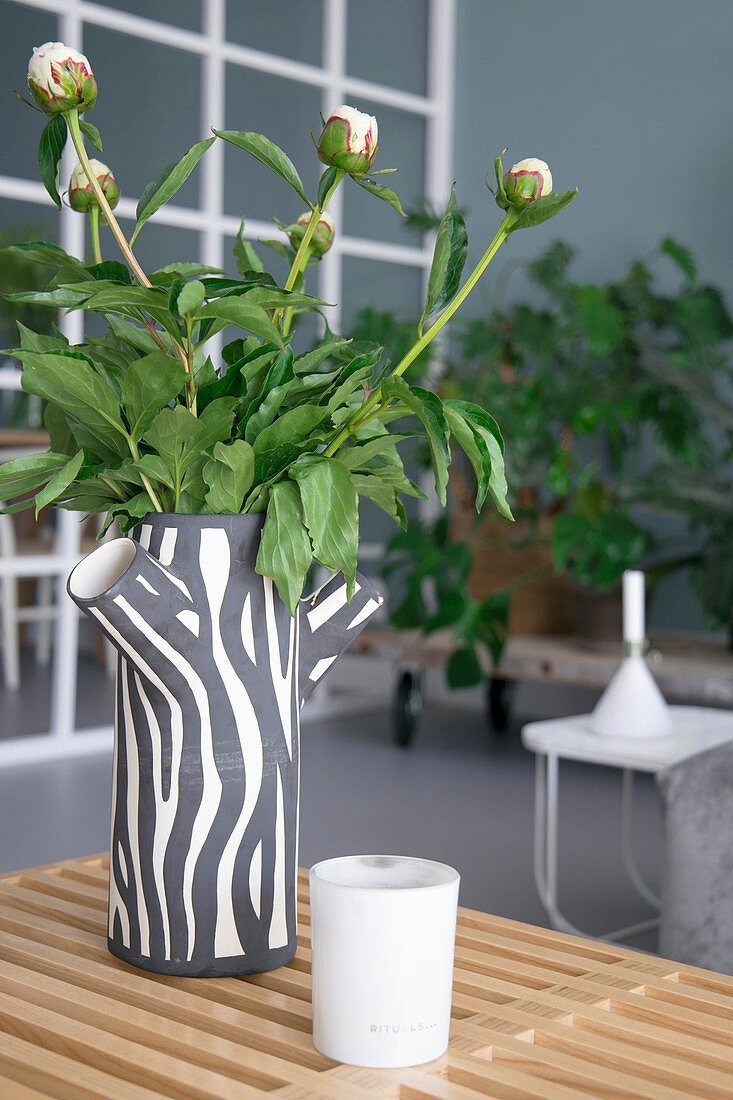 Peonies in vase with tree trunk effect