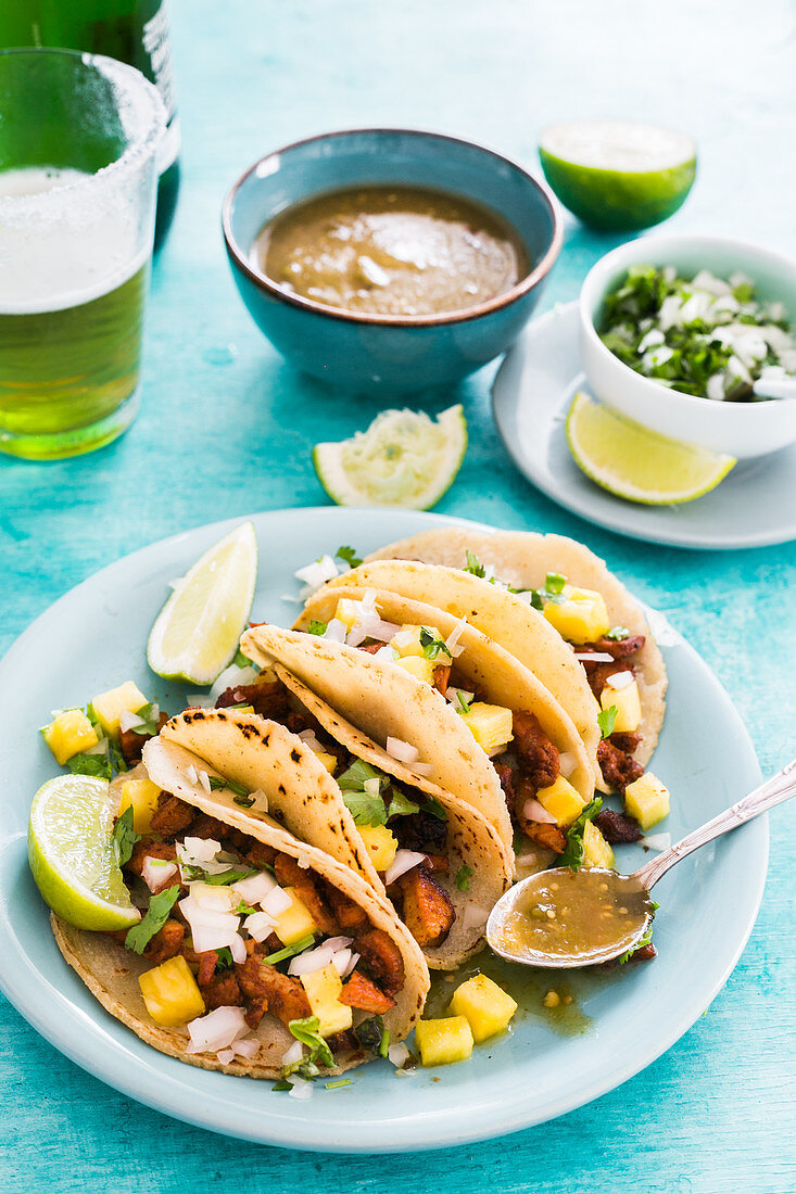 Tacos al pastor (with pineapple and green sauce, onions, cilantro and lime)